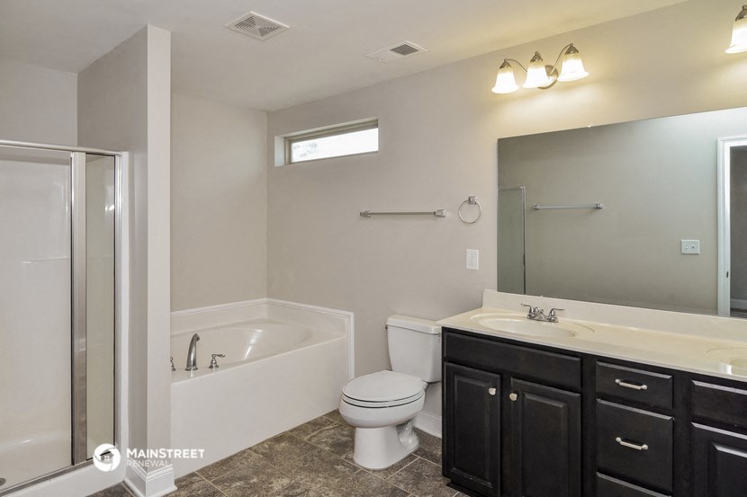 a bathroom with a toilet sink and a shower and a mirror