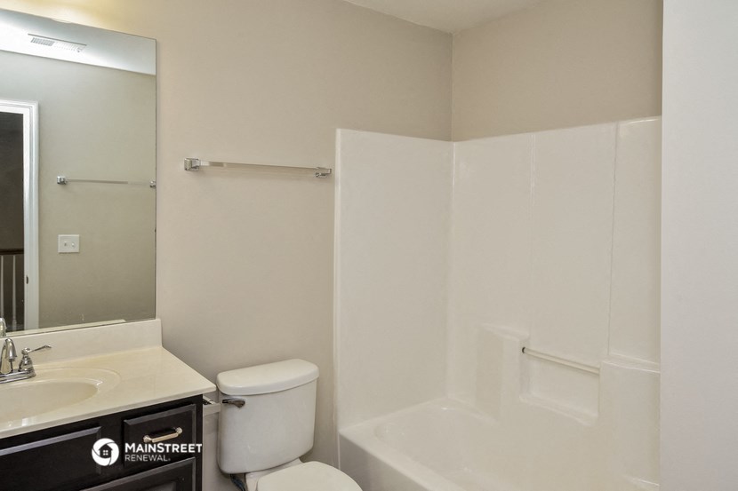 a bathroom with a shower toilet and sink and a mirror