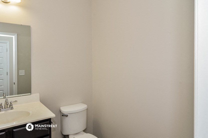 a bathroom with a toilet and a sink and a mirror