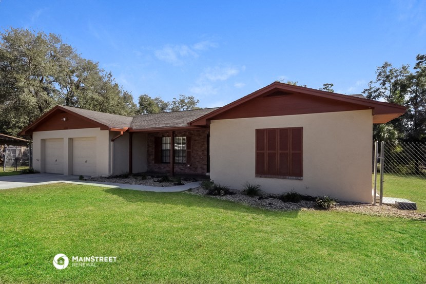 a remodeled home with a lawn and a garage