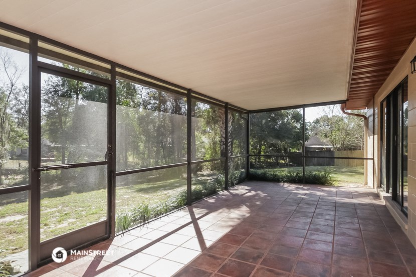 a living room with large glass windows and a view of the yard