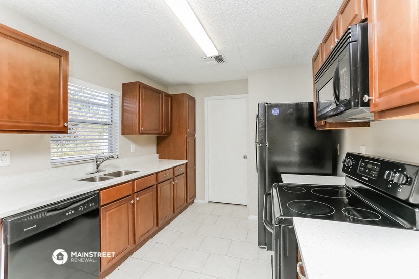 a kitchen with black appliances and wooden cabinets