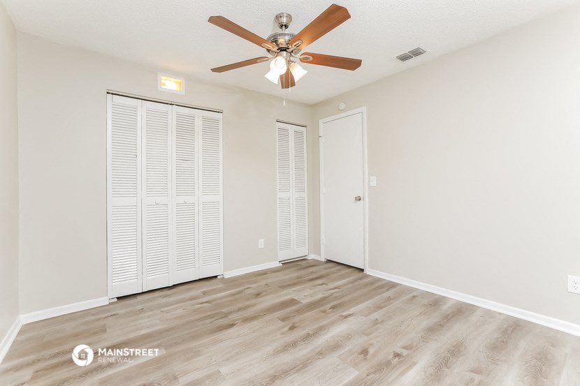 the living room of our two bedroom apartment atrium with ceiling fan and closet