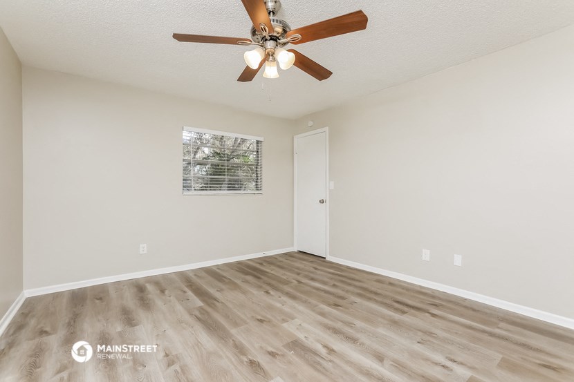 the living room of our studio apartment atrium with a ceiling fan
