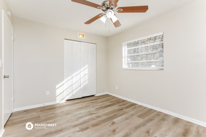 a living room with a ceiling fan and a window