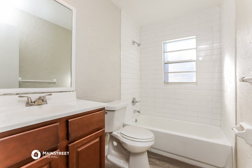 a bathroom with a toilet and a tub and a sink