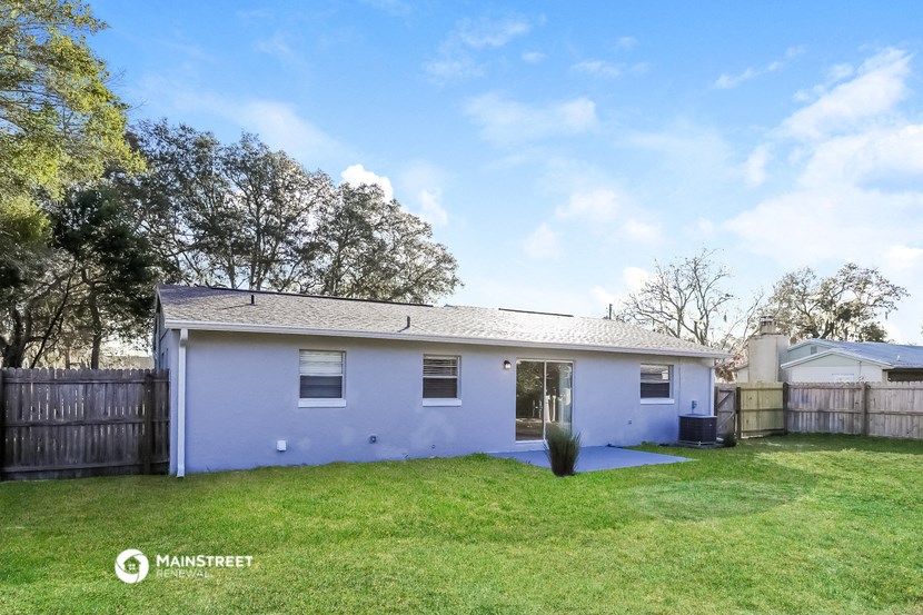 a small white house with a yard and a fence