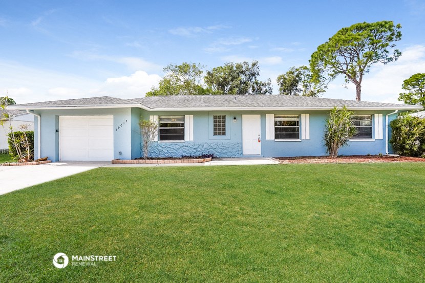 a blue house with a lawn and a white garage door