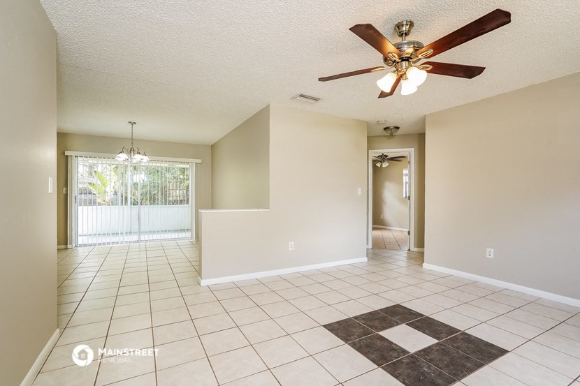 the living room and dining room with a ceiling fan
