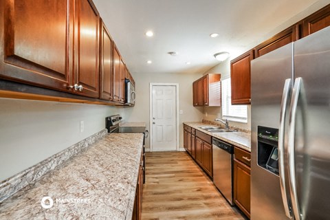 a kitchen with wooden cabinets and stainless steel appliances