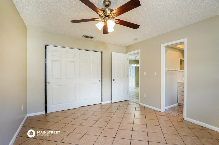 the living room has a ceiling fan and tile flooring