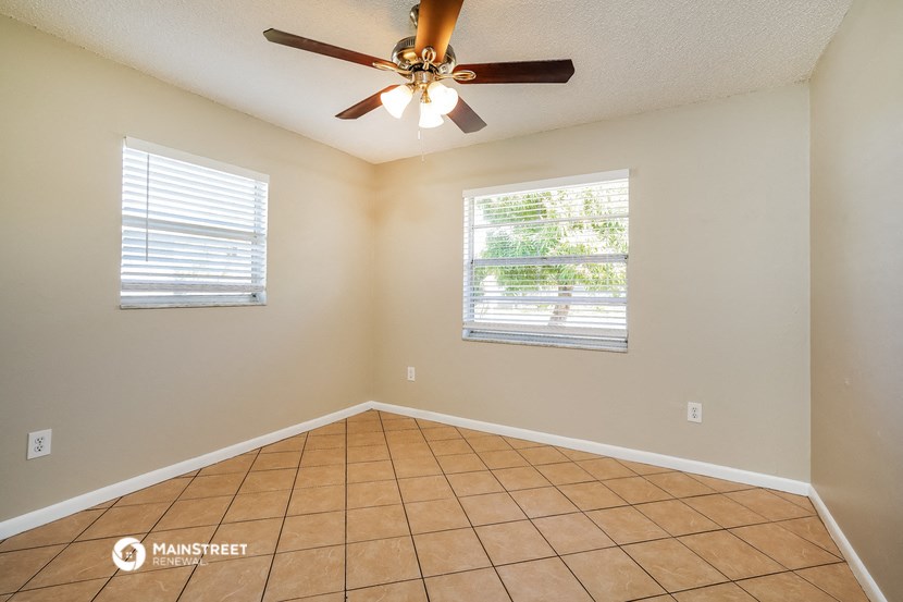 the living room has a ceiling fan and a tiled floor