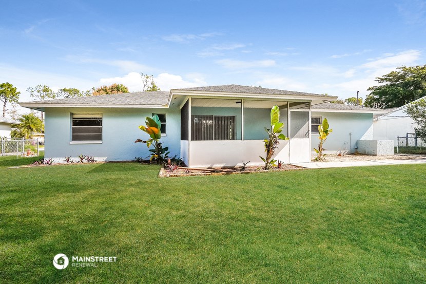 a small blue house with a yard and grass