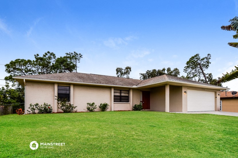 a white house with a grassy yard and a garage