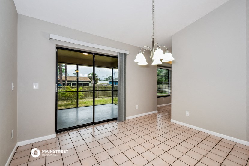 an empty living room with a sliding glass door to a patio