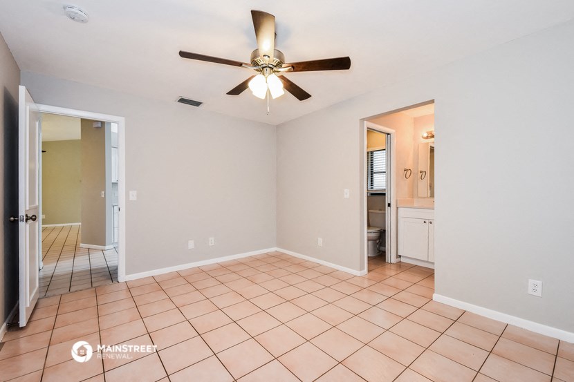 the living room has a ceiling fan and a tiled floor