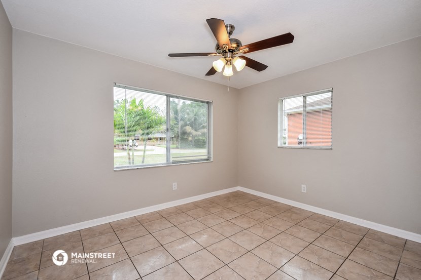 the living room has a large window and a ceiling fan