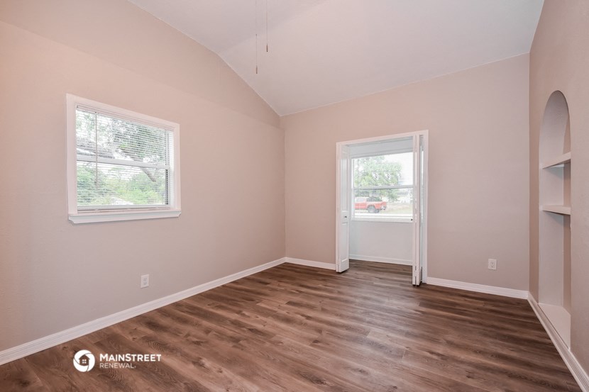 the living room of a home with a hardwood floor and a window