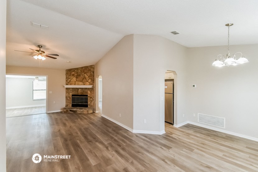 the living room with fireplace and wood flooring