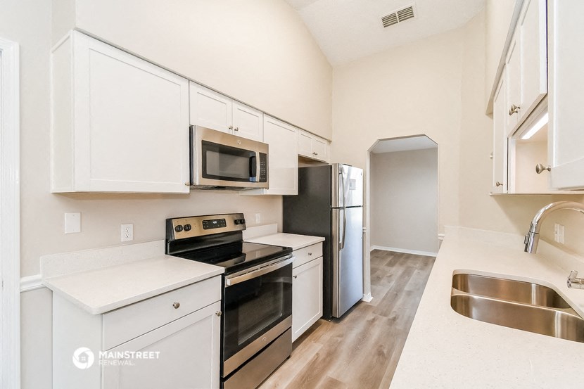 a kitchen with white cabinets and stainless steel appliances