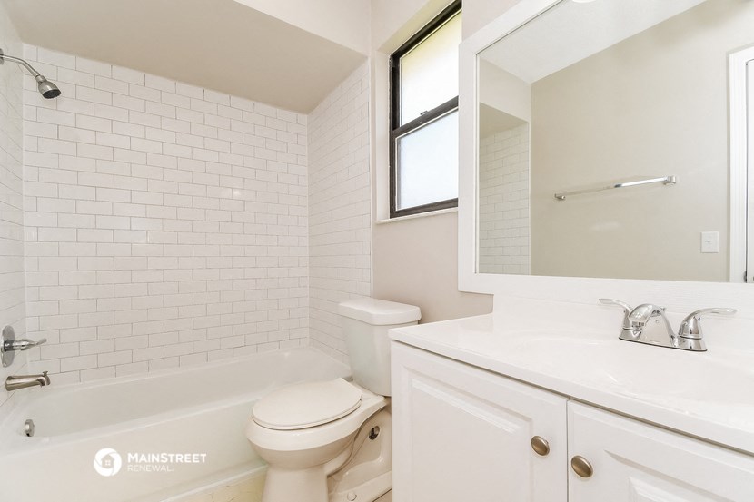 a white bathroom with a sink and a toilet and a bath tub