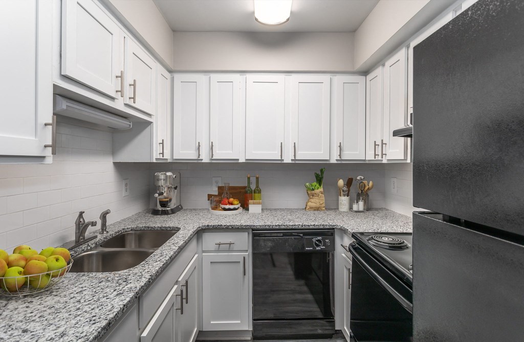 a kitchen with white cabinets and granite counter tops