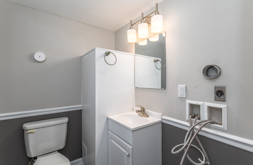 a bathroom with a toilet and a sink and a mirror