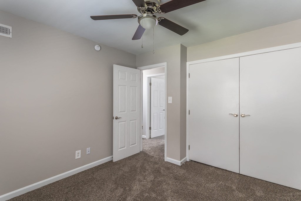 a bedroom with a ceiling fan and closet