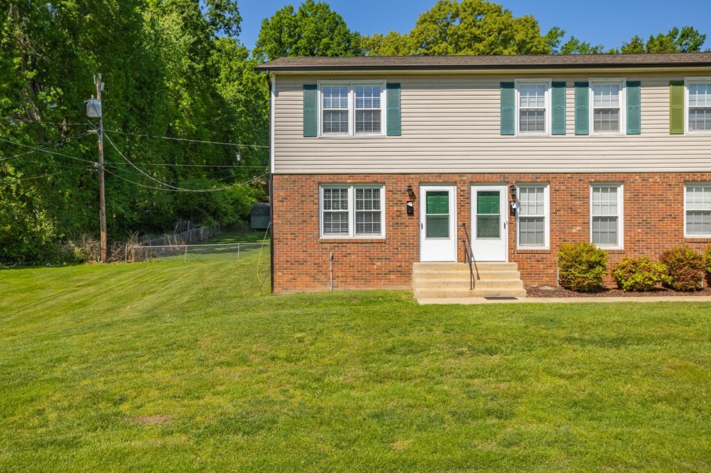 a white house with green shutters and a grassy yard