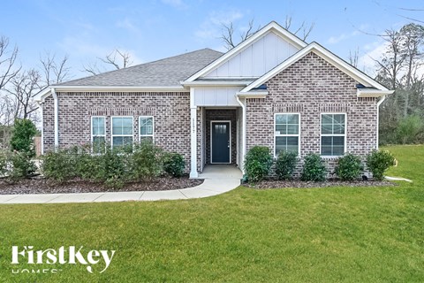 the front of a brick house with a sidewalk in front of it