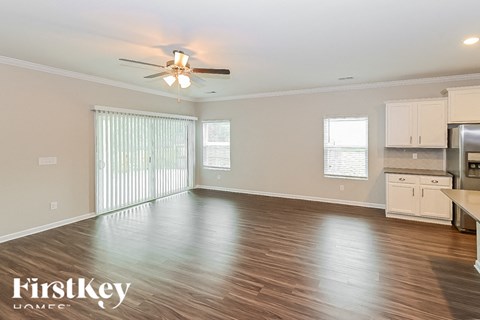 a kitchen and living room with wood flooring and a ceiling fan