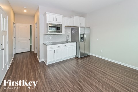 a kitchen with white cabinets and a stainless steel refrigerator