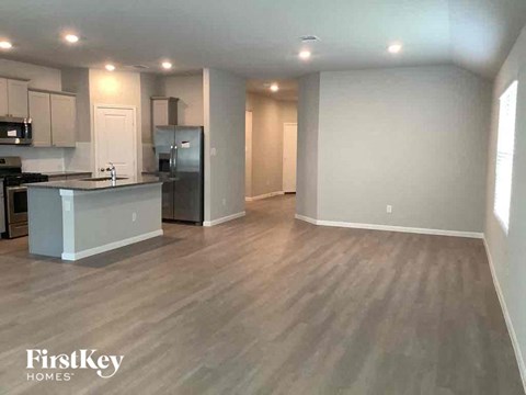 A kitchen with a refrigerator, microwave, and oven.