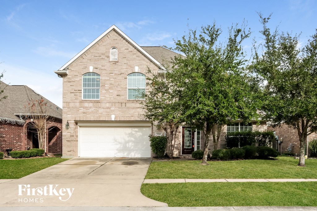 a brick house with a white garage door in front of it