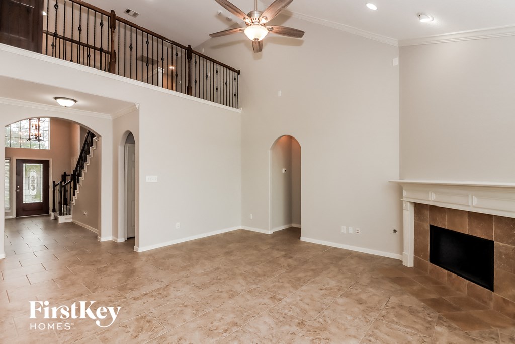a large living room with a fireplace and a ceiling fan
