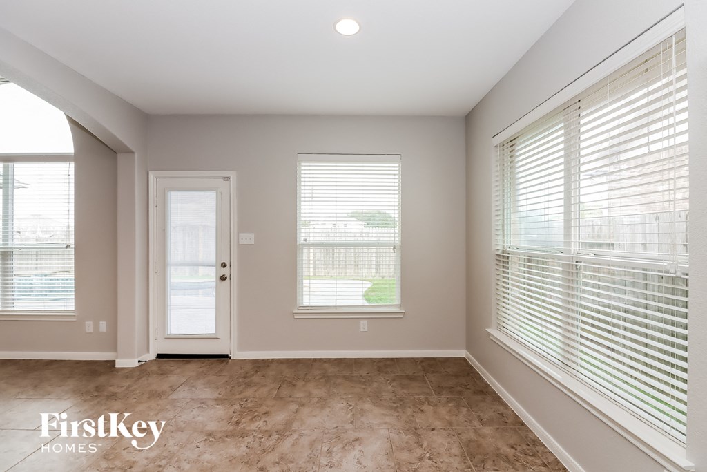 a living room with two large windows and a door