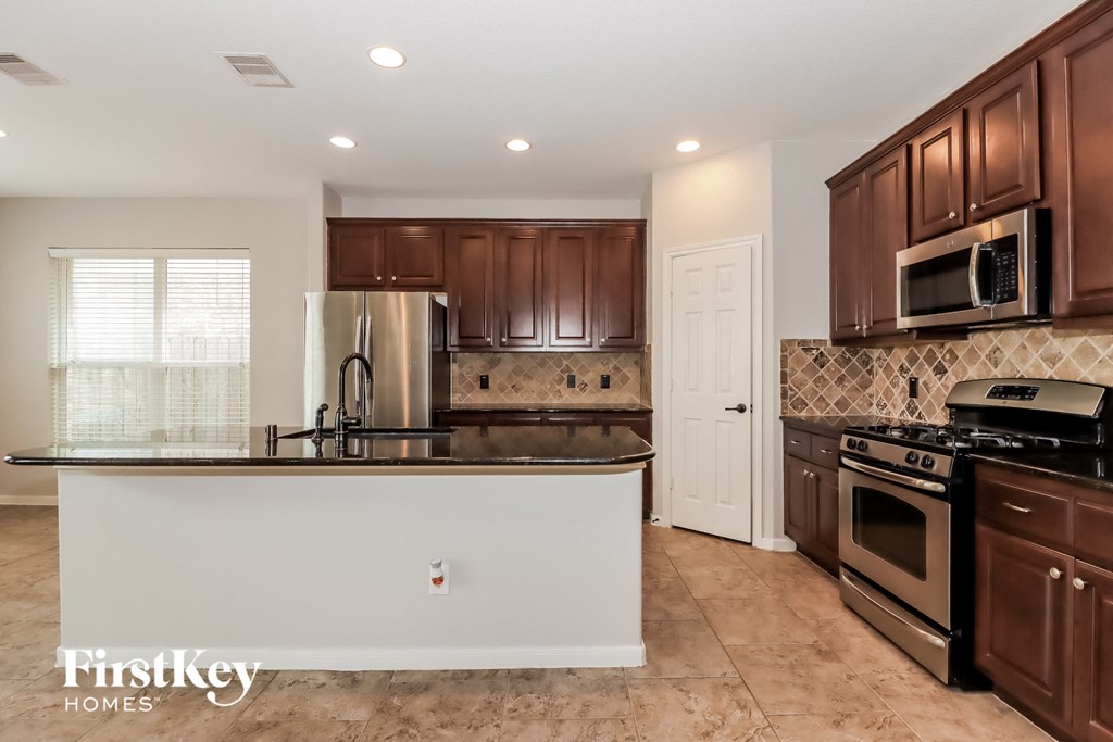 a kitchen with a large island and a stove and a refrigerator