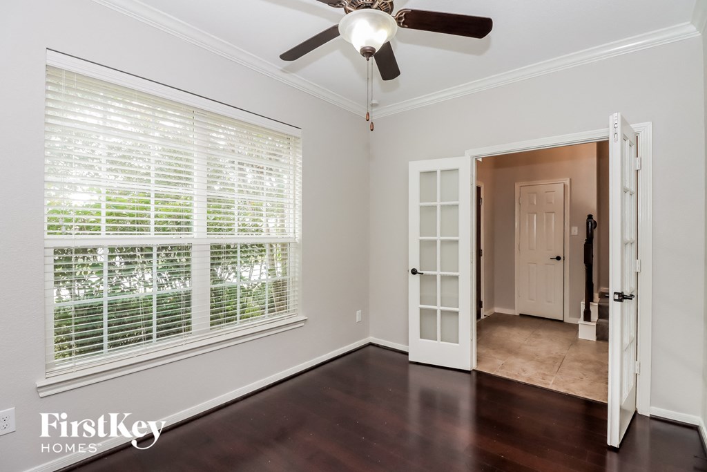 a living room with a large window and a ceiling fan