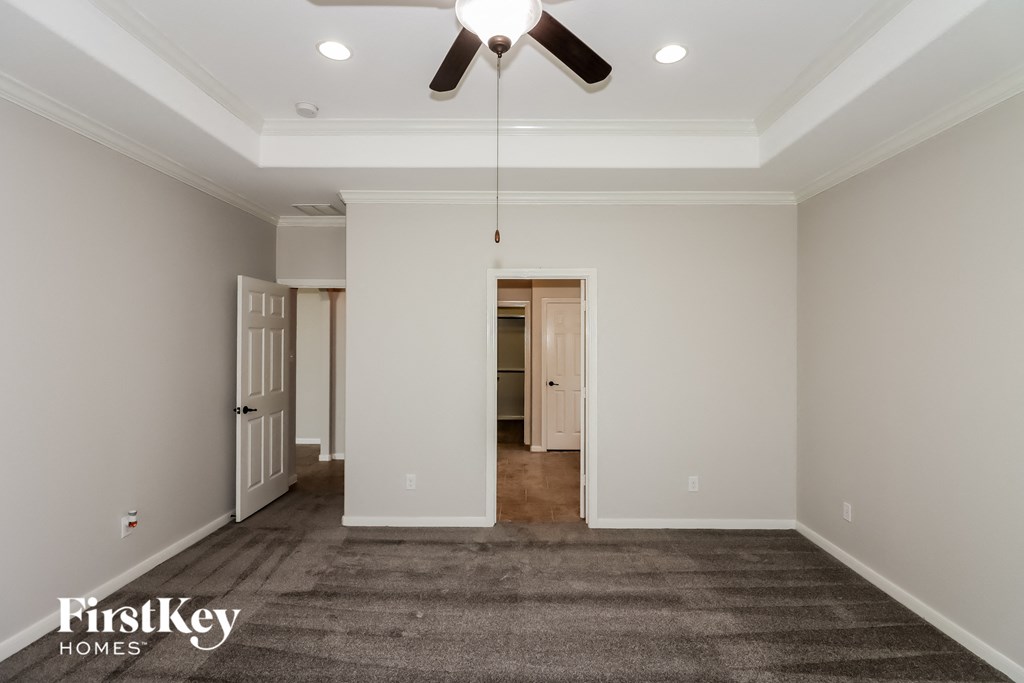 a living room with a carpet and a ceiling fan