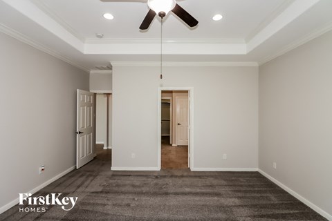 a living room with a carpet and a ceiling fan