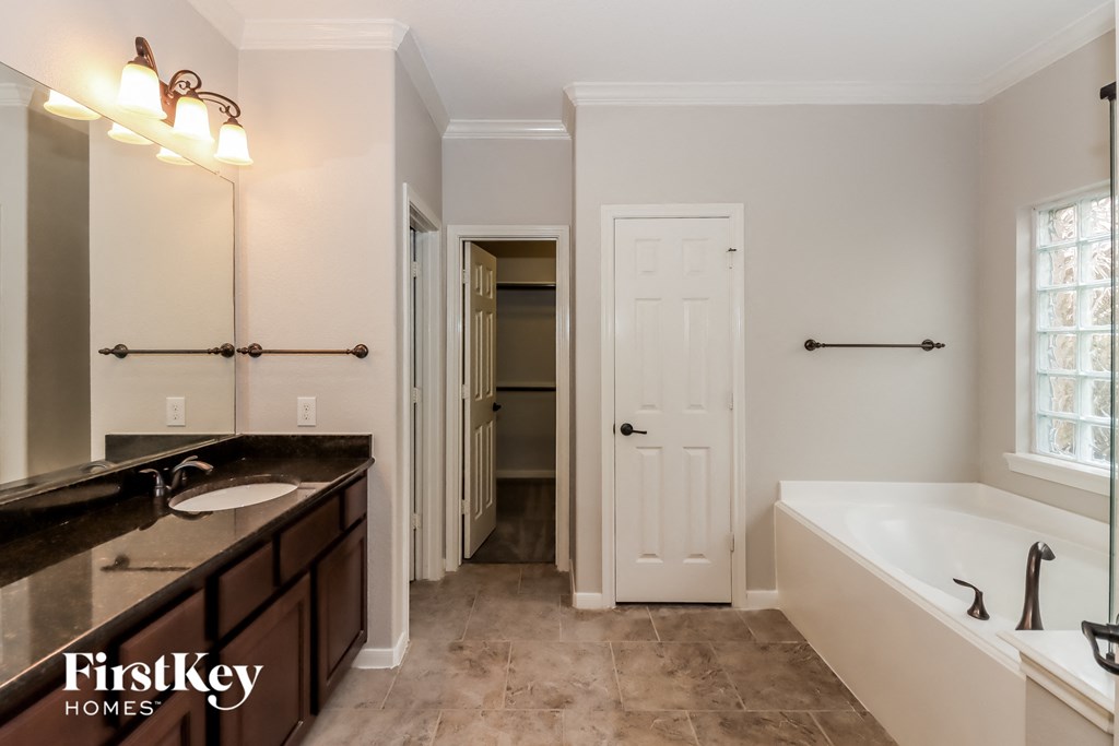 a bathroom with a tub and a sink and a mirror