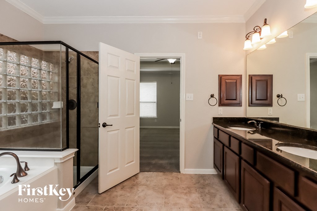 the master bathroom has a large shower and a double sink