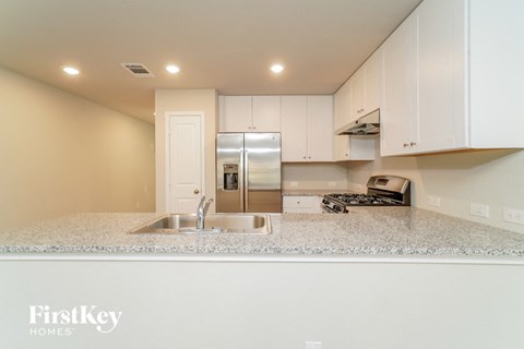 a kitchen with white cabinets and a granite counter top
