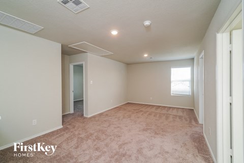 a spacious living room with carpet and a window