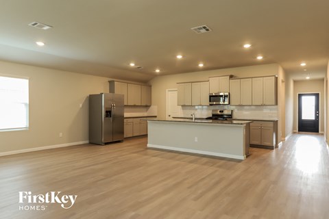 a large kitchen with white cabinets and stainless steel appliances