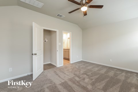 a living room with carpet and a ceiling fan