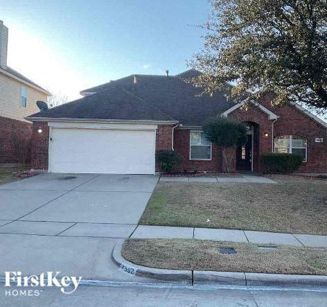 A brick house with a white garage door is for sale.