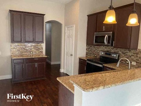 A kitchen with brown cabinets and a granite countertop.