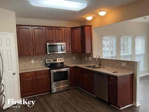 a kitchen with a stove and a sink and a microwave