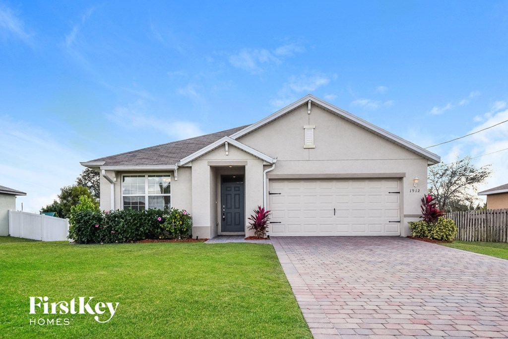 a white house with a lawn and a driveway